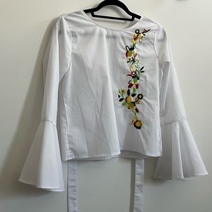 White shirt with bell sleeves, open back and embroidered flowers